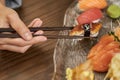 Person using chopsticks for eating sushi at a restaurant