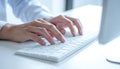Person Using Keyboard Close Up With Hands Typing on White Computer Keyboard At The Office Workplace Royalty Free Stock Photo