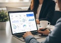 A person is using a laptop at a desk, with data analytics displayed Royalty Free Stock Photo