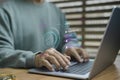 A person using a laptop with a digital fingerprint scan and virtual login interface, Royalty Free Stock Photo