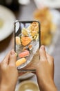 Person using mobile camera for photographing sushi meal