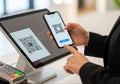 Person using a mobile device to complete a payment transaction through a QR code scan. This innovative technology provides a Royalty Free Stock Photo