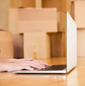 Person using notebook with cardboard boxes on background