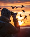 Person using portable binoculars to watch birds in flight, sunset, wide angle, showcasing zoom capability
