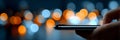 A Person Using a Smartphone at Night in a City, Surrounded by Blurry Lights and Modernity Royalty Free Stock Photo