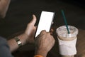 Person using smartphone, while he is resting in cafe, man hands holding smart phone with blank copy space screen for your text mes Royalty Free Stock Photo