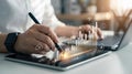 Person using stylus on tablet with digital charts and laptop in office analysis analytics Royalty Free Stock Photo