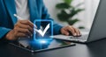 Person using stylus on tablet with digital checkmark and laptop technology Royalty Free Stock Photo