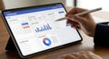 Person using a stylus on a tablet displaying a business dashboard Royalty Free Stock Photo