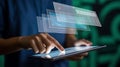 Person using a tablet with floating holographic digital interfaces in a dark environment Royalty Free Stock Photo