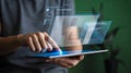 Person using a tablet to interact with a futuristic holographic interface displaying charts and data Royalty Free Stock Photo