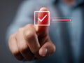 Person using a touchscreen interface to select a red checkmark symbol indicating confirmation or approval with a progress bar on a Royalty Free Stock Photo