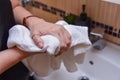 Person using towel for wiping hands dry after washing in bathroom at home Royalty Free Stock Photo