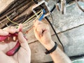 Electrician working on wiring in a residential garage during daylight hours using wire strippers and handling multiple Royalty Free Stock Photo