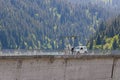 Person and a vehicle on the dam in Longrin, Switzerland with a forest in the background