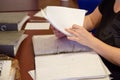 A person viewing the documents on the table in the living room, you can see hands and documents.