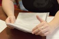 A person viewing the documents on the table in the living room, you can see hands and documents.