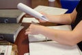 A person viewing the documents on the table in the living room, you can see hands and documents.