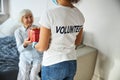 Person in a volunteer shirt delivering a present box