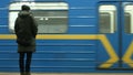 Person waiting train inside subway station platform.