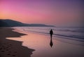 person walking along the beach towards the ocean at sunset with footprints in the wet sand Royalty Free Stock Photo