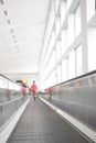 Person walking away on airport walkway Royalty Free Stock Photo