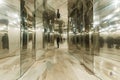 A person walking down a hallway with mirrored walls reflecting their image back, Mirrored walls creating an optical illusion Royalty Free Stock Photo