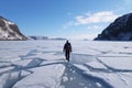 person, walking through frozen fjord, with snowshoes and backpack visible