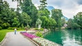 Person walking inside Parco Civico Ciani public garden with flowers along Lake Lugano banks in Lugano Ticino Switzerland