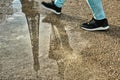 A person walking next to the reflection of the silhouette of the Eiffel tower in a puddle, Champ de Mars, Paris, France