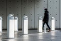 person walking past a series of white, sleek, energyefficient light fixtures