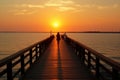 A person walking on a pier at sunset