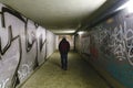 Person walking in subway underpass - light at the end of the tunnel - man walking alone in a potentially dangerous place