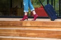 Person walking on wooden terrace pulling Travel Suitcase Royalty Free Stock Photo