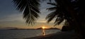 Person walks on the beach during tropical sunset