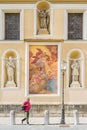 Ljubljana, Slovenia - August 15, 2018: A man pass by some of the artwork on the south facade of the Ljubljana Cathedral