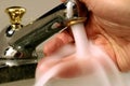 Person washing hand under tap