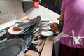 Person washing pile of dirty plates in a mundane task in a traditional restaurant in Asia Royalty Free Stock Photo