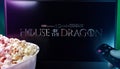 Person watching House of the Dragon on TV with popcorn and remote control. Stock editorial photo.