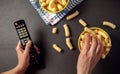 Person watching a TV and eat snacks, corn puffs Royalty Free Stock Photo