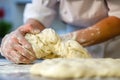 person wearing a chefs hat checking dough texture for elasticity