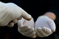 Person wearing disposable gloves giving a coin to a hand beggar Royalty Free Stock Photo