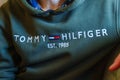 Person is wearing a green Tommy Hilfiger sweatshirt. Selective focus