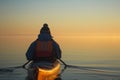 person wearing a life jacket paddling on calm waters at sunrise Royalty Free Stock Photo