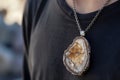 person wearing a petrified wood pendant on a chain