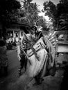 Black and white photo a person wearing a red bird costume at a cultural event in the village of Kemiren Banyuwangi