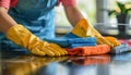 A person wearing yellow gloves cleans the counter with cloths Royalty Free Stock Photo