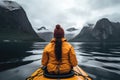 A person wearing a yellow jacket is seen kayaking in a vibrant yellow kayak on a calm river, View from the back of a girl in a