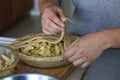 Person weaving dough strips on an apple pie Royalty Free Stock Photo