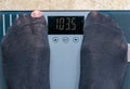 Person weighing himself on a electronic scale with black socks